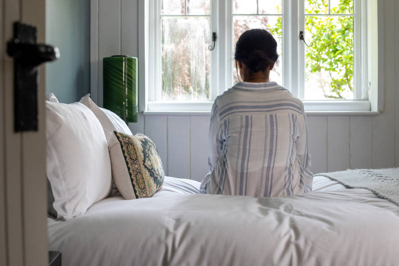 A person suffering from depression, looking out a window.