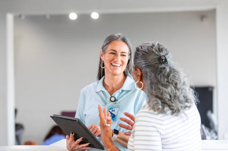 An older woman talking to a therapist about outpatient programs, and the difference between PHP and IOP.
